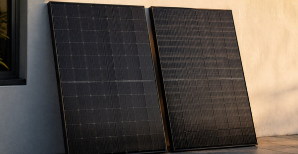 Two premium all-black solar panels angled side by side for comparison