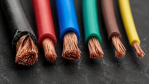 Close-up of stripped copper wire ends in several AWG gauges side by side