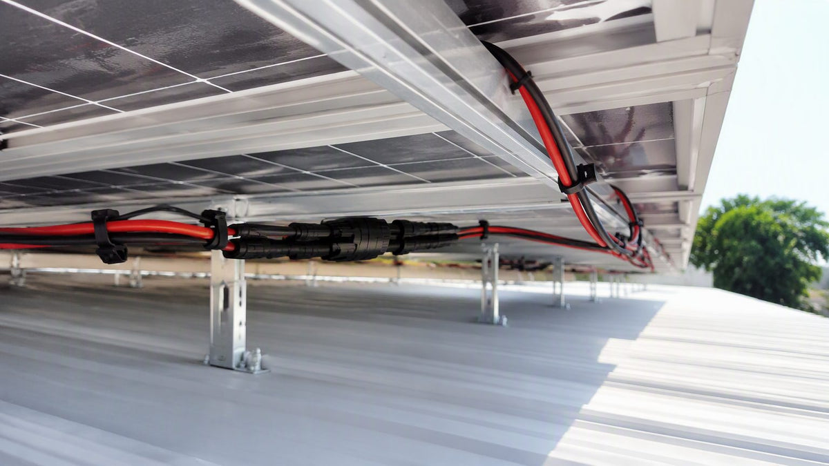 Cableado PV con conectores tipo MC4 bajo un arreglo solar en tejado
